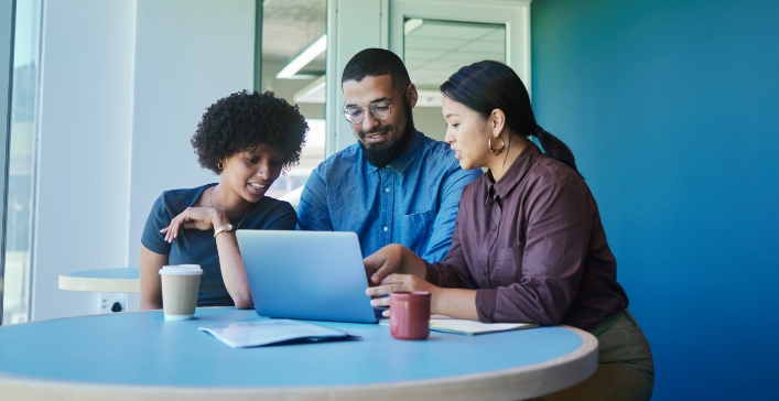 3 people sitting around a computer